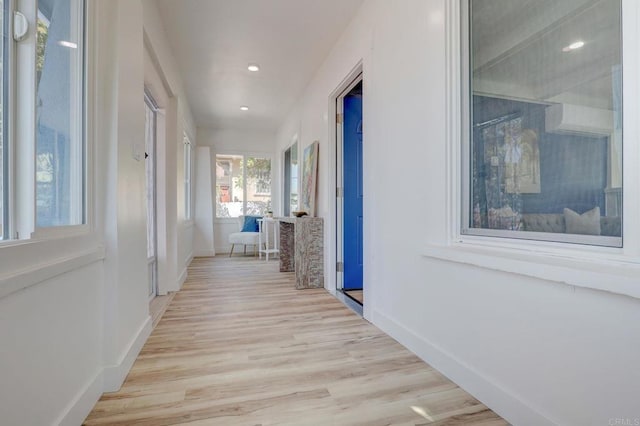 corridor featuring light wood finished floors, recessed lighting, and baseboards