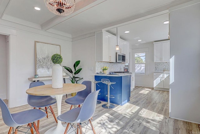 dining room featuring light wood finished floors, beam ceiling, recessed lighting, and baseboards