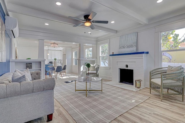 living room with a wall unit AC, wood finished floors, plenty of natural light, beamed ceiling, and ceiling fan