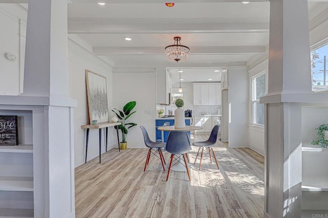 dining area featuring beam ceiling, light wood-style flooring, and a chandelier