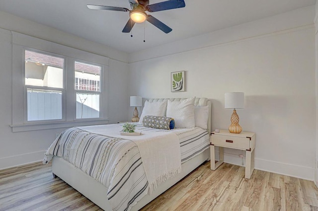 bedroom featuring baseboards, light wood-style flooring, and a ceiling fan