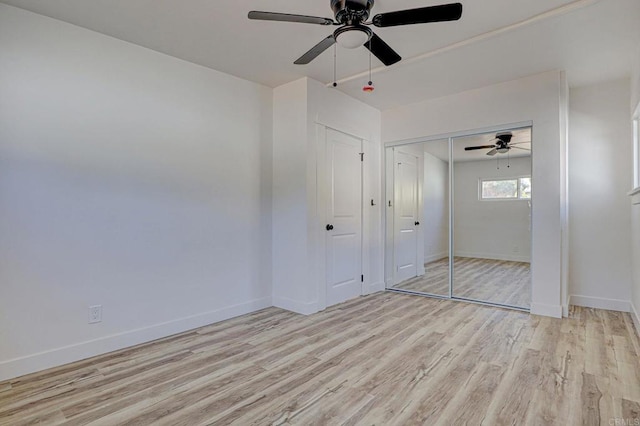 unfurnished bedroom featuring light wood-style floors, baseboards, a closet, and ceiling fan