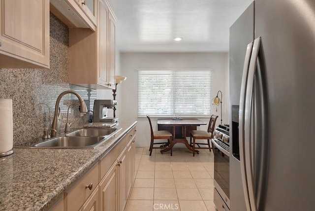 kitchen with appliances with stainless steel finishes, a sink, light tile patterned floors, backsplash, and recessed lighting