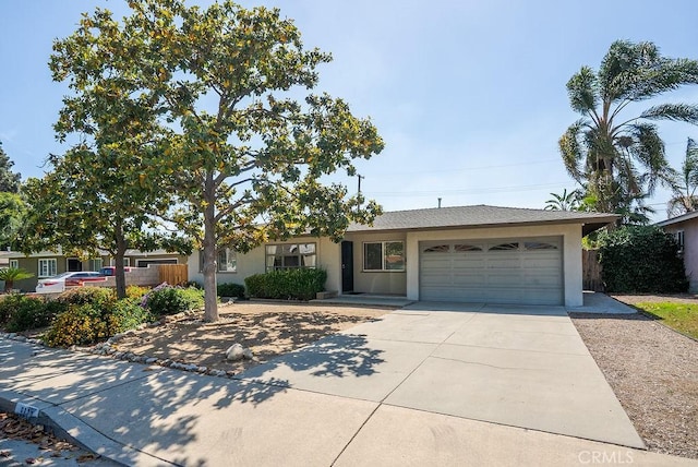 ranch-style home featuring stucco siding, concrete driveway, an attached garage, and fence