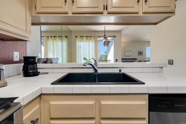 7488 Altiva Pl, Carlsbad, CA 92009 - kitchen featuring stainless steel dishwasher, a sink, tile counters, and cream cabinetry
