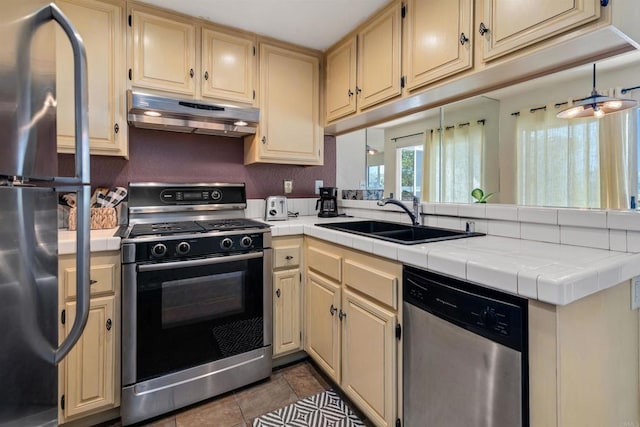 7488 Altiva Pl, Carlsbad, CA 92009 - kitchen featuring appliances with stainless steel finishes, under cabinet range hood, cream cabinetry, and a sink