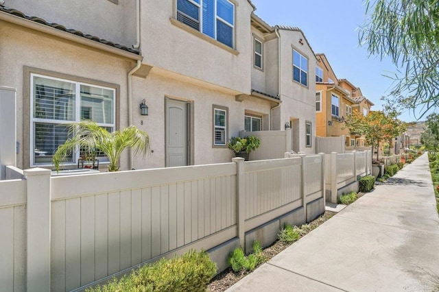 exterior space with fence, a residential view, and stucco siding