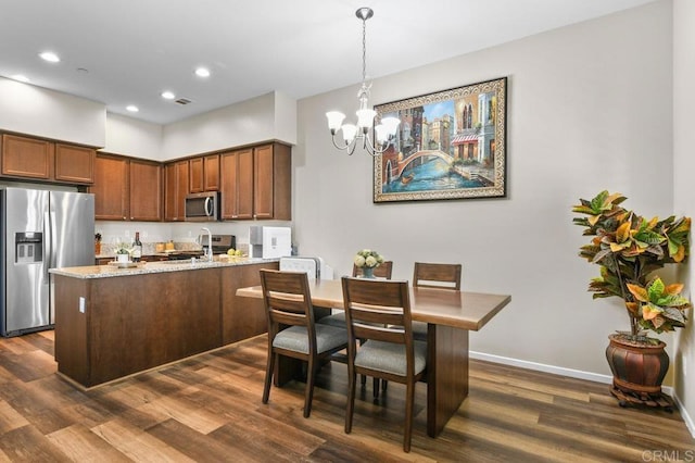 dining room with a chandelier, dark wood finished floors, baseboards, and recessed lighting