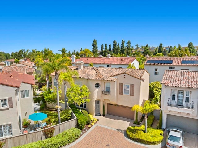 7256 Surfbird Cir, Carlsbad, CA 92011 - mediterranean / spanish house featuring a garage, a residential view, a tiled roof, stucco siding, and decorative driveway