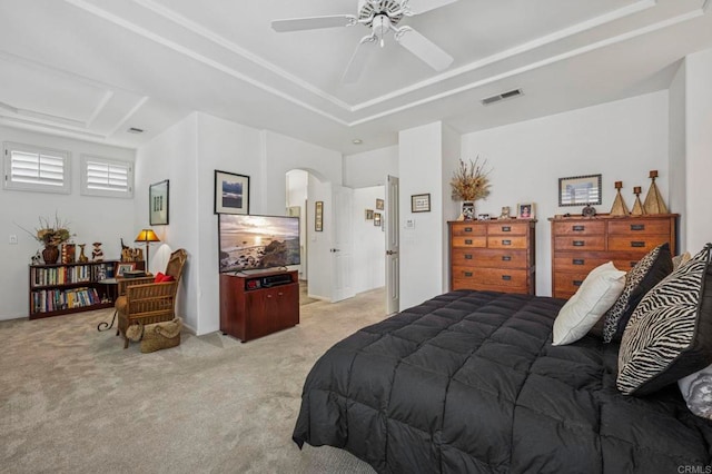 7256 Surfbird Cir, Carlsbad, CA 92011 - bedroom with light colored carpet, arched walkways, a raised ceiling, and a ceiling fan