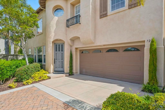7256 Surfbird Cir, Carlsbad, CA 92011 - view of exterior entry with a garage, stucco siding, and concrete driveway