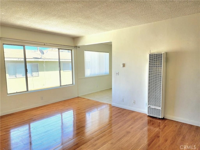 2616 Gates Ave, Redondo Beach, CA 90278 - spare room featuring a heating unit, a textured ceiling, wood finished floors, and baseboards