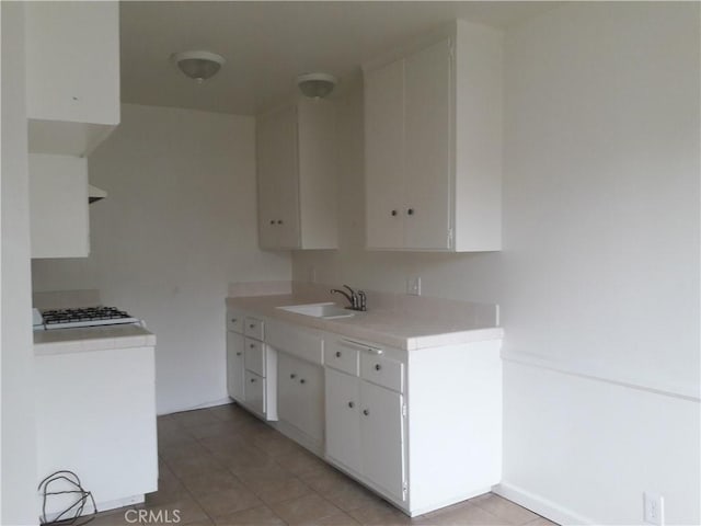 2616 Gates Ave, Redondo Beach, CA 90278 - kitchen with a sink, light countertops, light tile patterned floors, and white cabinetry
