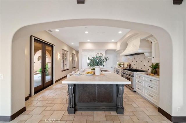 7 Ocean Heights Dr, Newport Coast, CA 92657 - kitchen with double oven range, white cabinets, light countertops, decorative backsplash, and recessed lighting