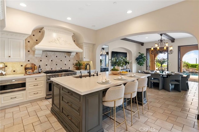 7 Ocean Heights Dr, Newport Coast, CA 92657 - kitchen with stainless steel appliances, a sink, custom exhaust hood, a kitchen breakfast bar, and tasteful backsplash