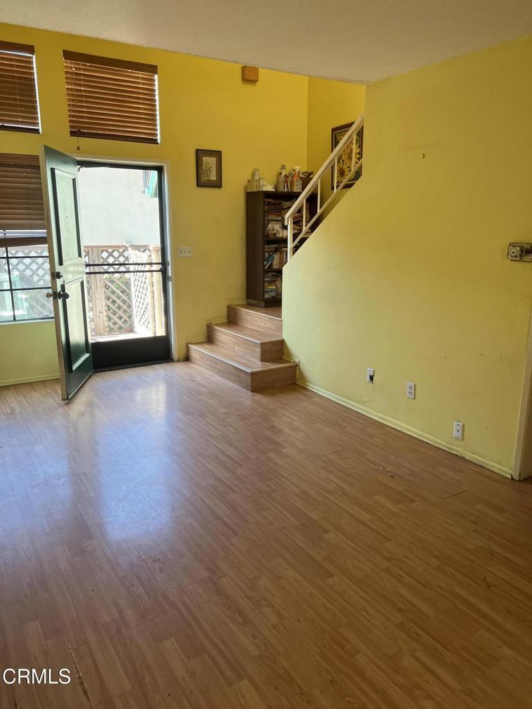 170170 N Sierra Bonita Ave Unit 11, Pasadena, CA 91106 - unfurnished living room featuring stairs, wood finished floors, and baseboards