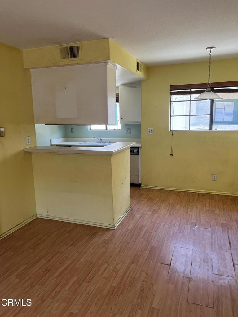 170170 N Sierra Bonita Ave Unit 11, Pasadena, CA 91106 - kitchen with wood finished floors, dishwasher, a peninsula, light countertops, and baseboards