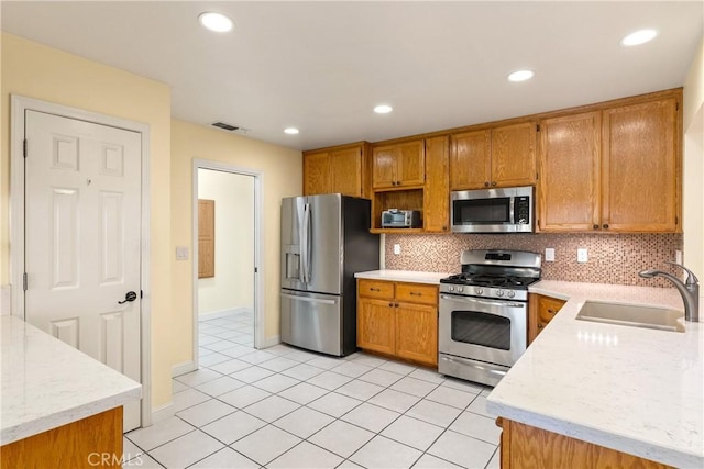 156 Greenfield Dr, Chico, CA 95973 - kitchen with stainless steel appliances, a sink, backsplash, brown cabinetry, and recessed lighting
