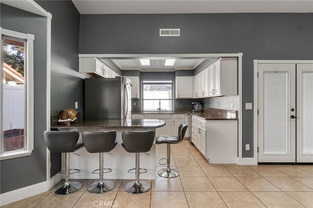 2505 Stuart Ave, Clovis, CA 93611 - kitchen with freestanding refrigerator, a sink, a peninsula, and white cabinets