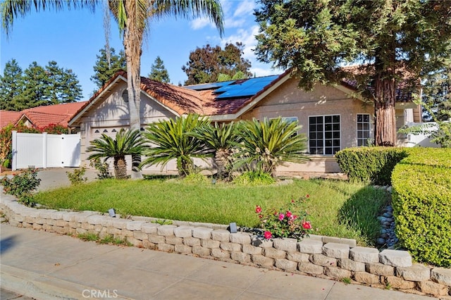 2505 Stuart Ave, Clovis, CA 93611 - view of front of home with solar panels, an attached garage, fence, stucco siding, and concrete driveway