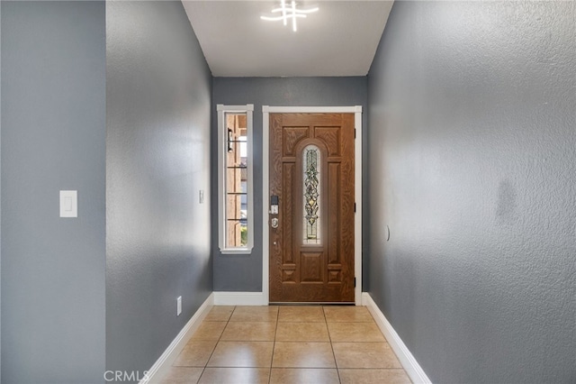 2505 Stuart Ave, Clovis, CA 93611 - doorway to outside with baseboards, light tile patterned flooring, and a textured wall