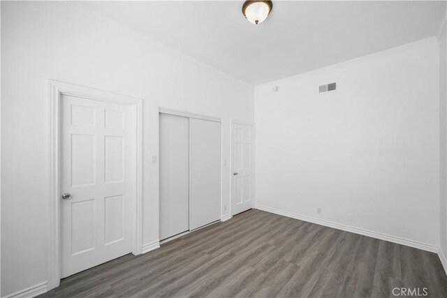 11954 Mayfield Ave Unit 3, Los Angeles, CA 90049 - unfurnished bedroom featuring wood finished floors, a closet, baseboards, and crown molding