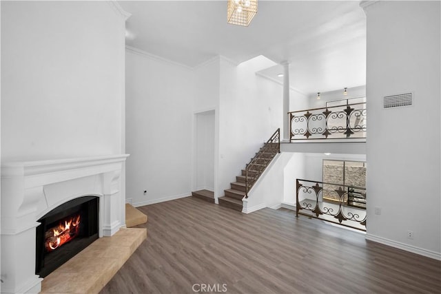 11954 Mayfield Ave Unit 3, Los Angeles, CA 90049 - unfurnished living room featuring wood finished floors, a tiled fireplace, stairs, a high ceiling, and baseboards