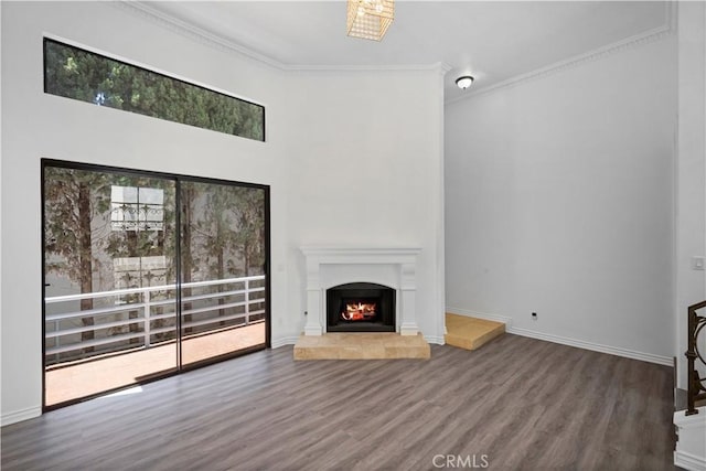 11954 Mayfield Ave Unit 3, Los Angeles, CA 90049 - unfurnished living room featuring wood finished floors, ornamental molding, a tile fireplace, baseboards, and a towering ceiling