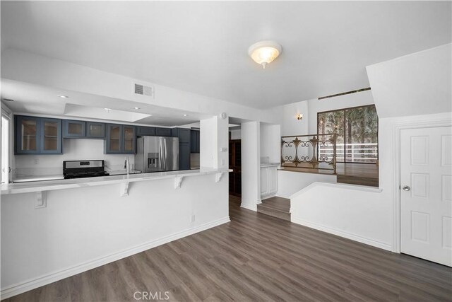 11954 Mayfield Ave Unit 3, Los Angeles, CA 90049 - kitchen featuring stainless steel appliances, a kitchen breakfast bar, and dark wood-type flooring