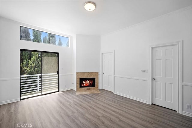 11954 Mayfield Ave Unit 3, Los Angeles, CA 90049 - unfurnished living room with wood finished floors, a tiled fireplace, and baseboards