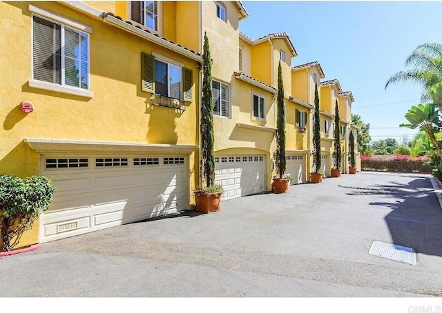 view of property with a garage, a residential view, and driveway