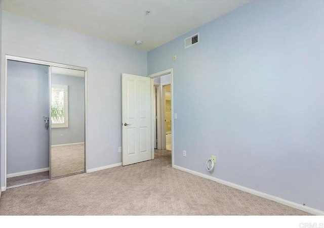 unfurnished bedroom featuring carpet, a closet, and baseboards