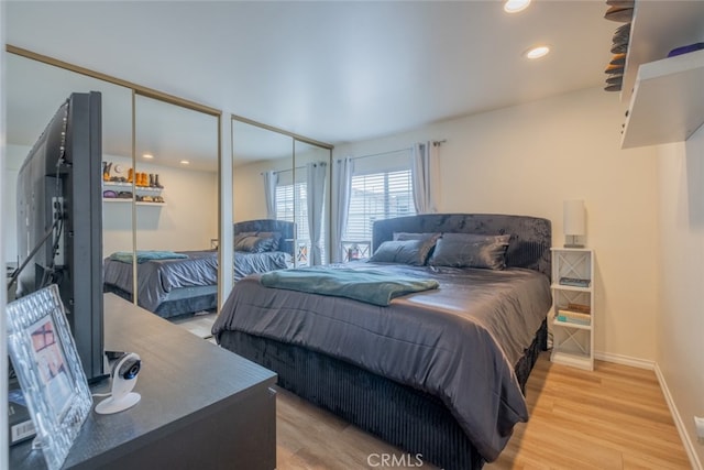 bedroom with light wood-type flooring, multiple closets, baseboards, and recessed lighting