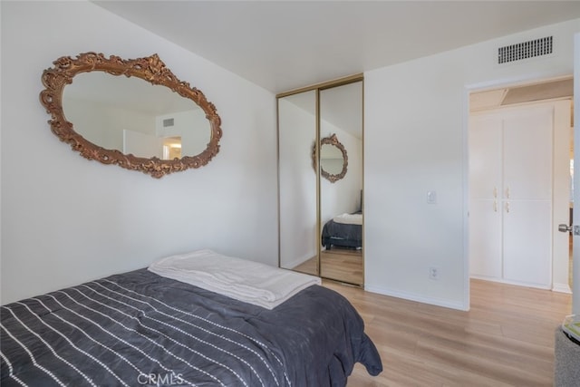 bedroom featuring a closet, wood finished floors, and baseboards
