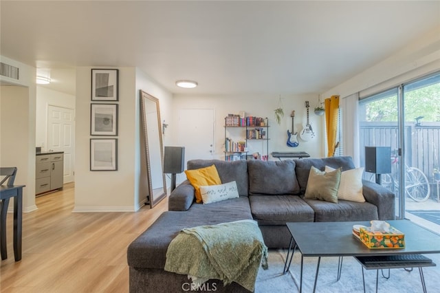living area featuring light wood-type flooring and baseboards