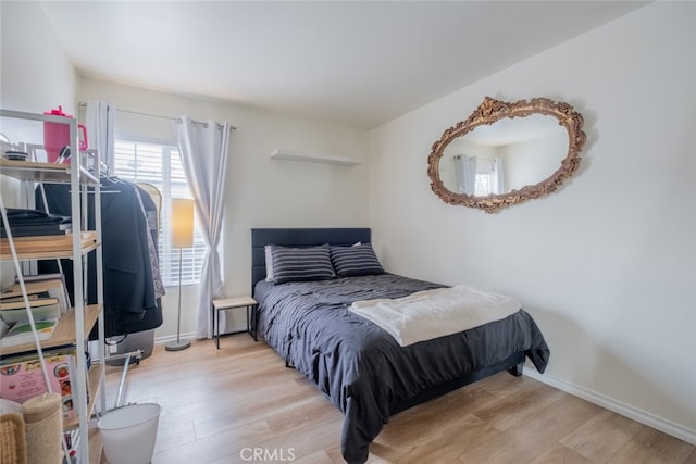 bedroom with light wood finished floors and baseboards