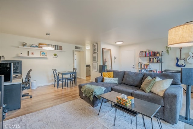 living room featuring light wood-type flooring, an office area, and baseboards