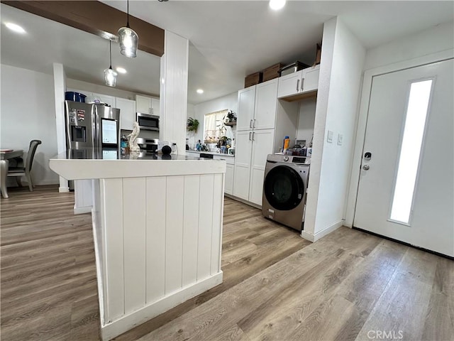309 Santo Dr, San Jacinto, CA 92583 - kitchen with appliances with stainless steel finishes, washer / clothes dryer, light wood-style flooring, recessed lighting, and white cabinets
