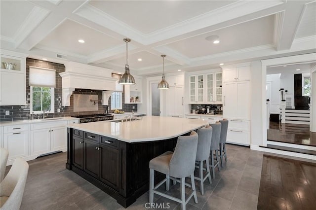 2711 Elm Ave, Manhattan Beach, CA 90266 - kitchen with white cabinets, beamed ceiling, light countertops, glass insert cabinets, and a spacious island