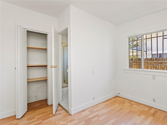 911 N Dos Robles Pl, Alhambra, CA 91801 - unfurnished bedroom with wood finished floors, baseboards, and a closet