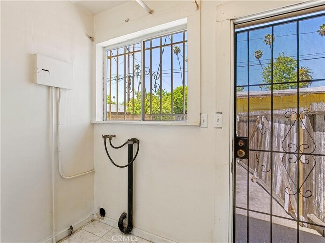 911 N Dos Robles Pl, Alhambra, CA 91801 - clothes washing area featuring healthy amount of natural light, washer hookup, baseboards, and tile patterned flooring
