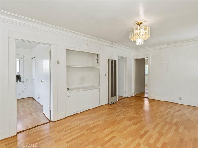 911 N Dos Robles Pl, Alhambra, CA 91801 - unfurnished bedroom featuring a chandelier, a heating unit, light wood-type flooring, crown molding, and baseboards