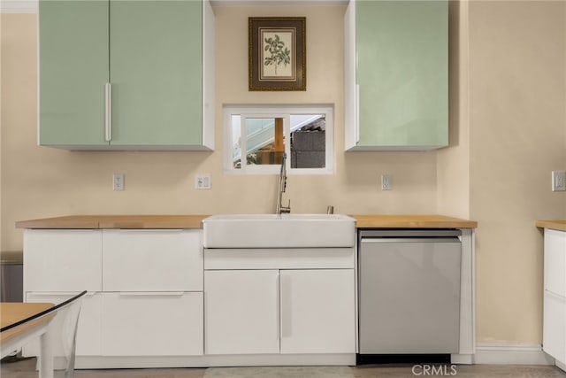 kitchen with dishwasher, a sink, and white cabinets