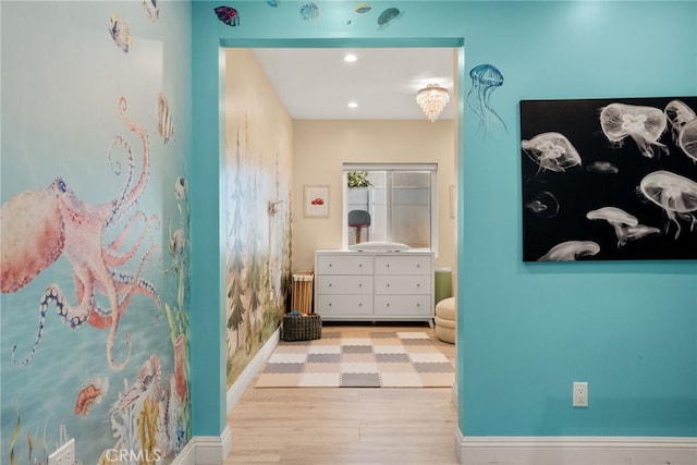 hall featuring light wood finished floors, baseboards, and recessed lighting