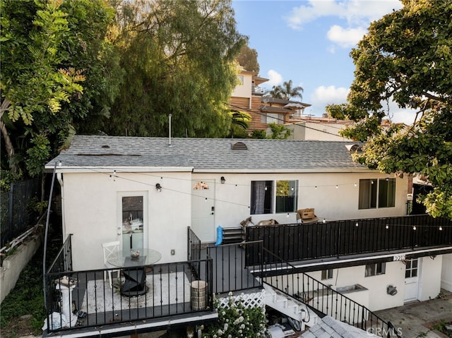 rear view of property featuring stairs, stucco siding, a shingled roof, and a patio