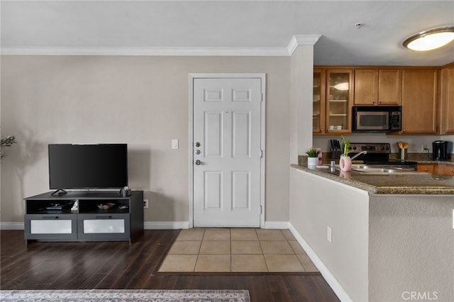 2045 Las Colinas Cir Unit 103, Corona, CA 92879 - kitchen with appliances with stainless steel finishes, brown cabinets, glass insert cabinets, wood finished floors, and ornamental molding