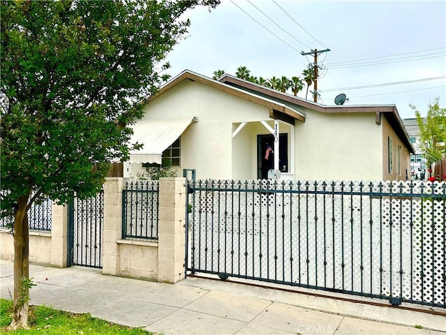 140 S Vendome St, Los Angeles, CA 90057 - view of front of home featuring stucco siding, a fenced front yard, and a gate