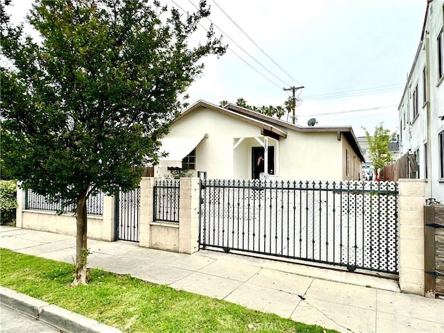 140 S Vendome St, Los Angeles, CA 90057 - view of front of home featuring stucco siding, a fenced front yard, and a gate