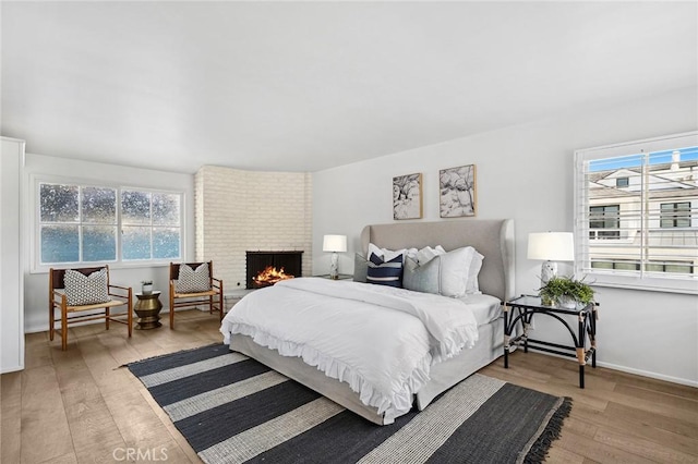 121 Onyx Ave, Newport Beach, CA 92662 - bedroom featuring hardwood / wood-style flooring, baseboards, and a brick fireplace