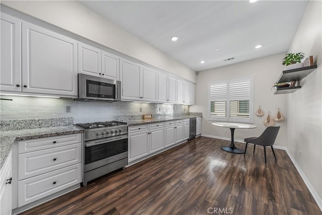 kitchen featuring appliances with stainless steel finishes, beverage cooler, white cabinets, and recessed lighting